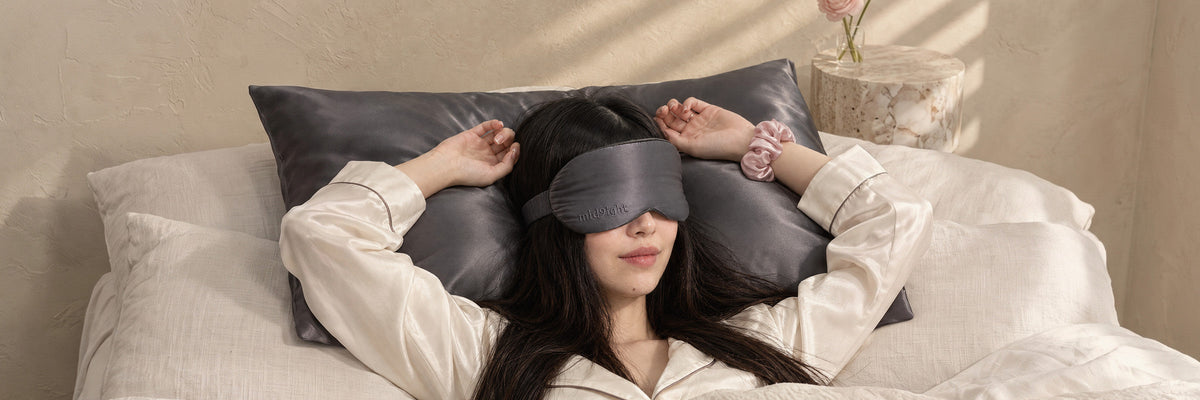 Model in Charcoal silk resting on a Charcoal pillowcase