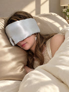 Debbie resting on the Mid9ight Dream Luxe mulberry silk pillowcase in Champagne, wearing the Deep Sleep eye mask in Moonlight
